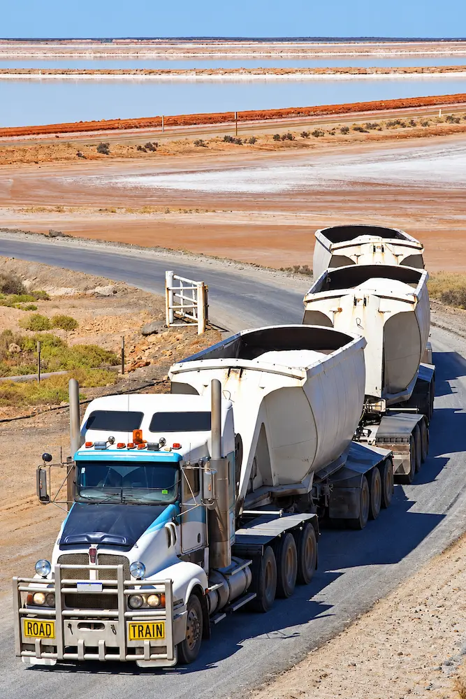 Road train on an outback highway beside salt flats