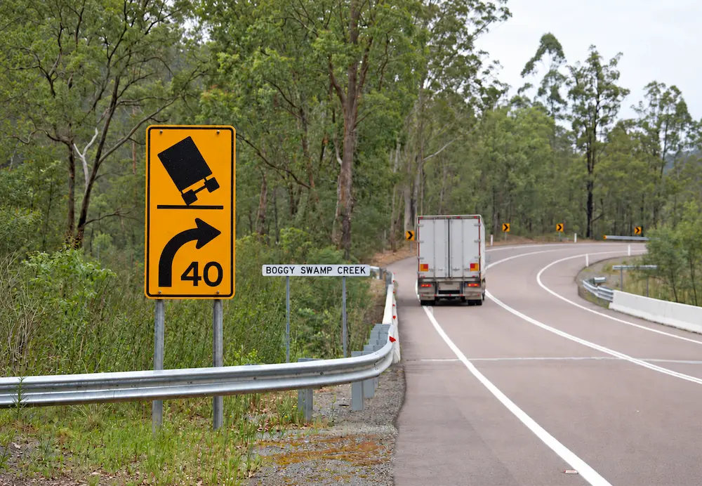 Slow down road sign for heavy vehicles