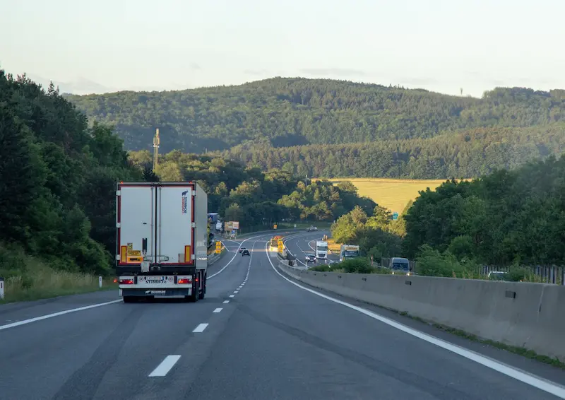 Truck driving on a highway through green hills